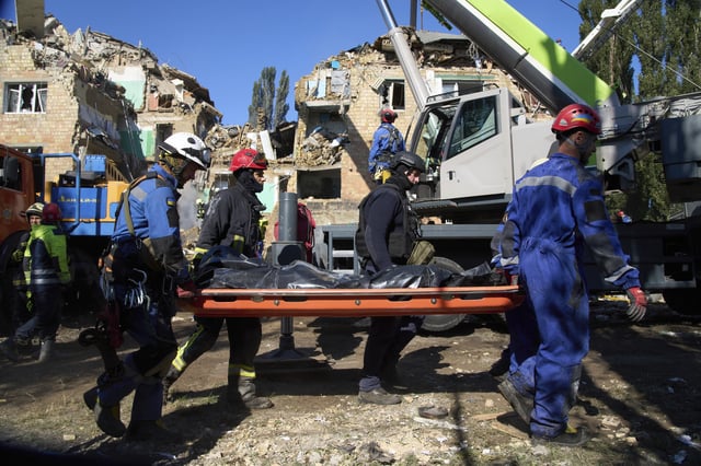 Firefighters carry a body in front of a damaged building after a Russian attack in Kyiv, Ukraine, Thursday, Aug. 28, 2025. (AP Photo/Efrem Lukatsky)
