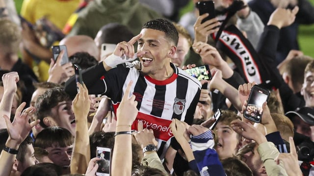 Jaze Kabia is lifted by fans during the jubilant celebrations after Grimsby’s 12-11 penalty shoot-out victory