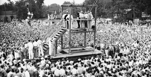 On Friday, Aug. 14, 1936, a large crowd watches as attendants adjust a black hood over Rainey Bethea's head just before his public hanging in Owensboro, Ky. Bethea, a 22-year-old black man convicted of raping a 70-year-old white woman, was the last person killed in a public execution in the United States. (AP File Photo)