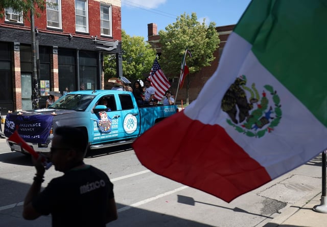 Community members wave flags during the Pilsen Mexican Independence Day Parade on Sept. 9, 2023. Organizers of the 2025 parade said Thursday that the upcoming celebration will go on despite the Trump administration's immigration crackdown. (Talia Sprague/Chicago Tribune)