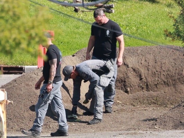 Investigators check an earth berm after a controlled detonation of explosive materials in the 4700 block of First Street S.W. on August 27, 2025.  
