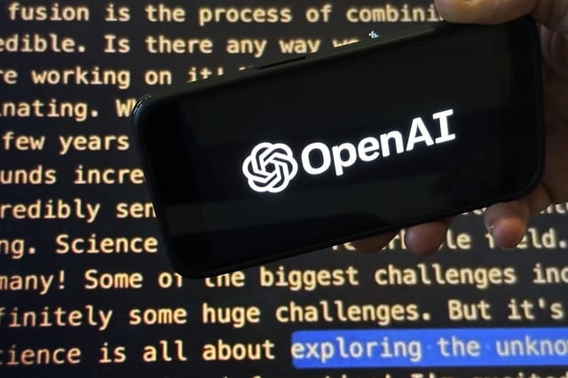 FILE - The OpenAI logo appears on a mobile phone in front of a screen showing part of the company website in this photo taken on Nov. 21, 2023 in New York. 