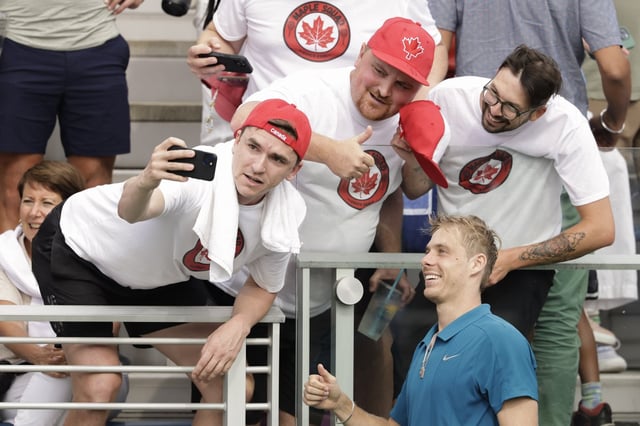 Denis Shapovalov, of Canada, poses for a photo with fans after defeating Valentin Royer, of France, during the second round of the U.S. Open tennis championships, Thursday, Aug. 28, 2025, in New York. (AP Photo/Adam Hunger)