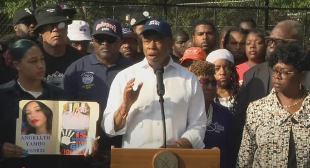 Mayor Adams speaks while surrounded by officials and Bronxites.