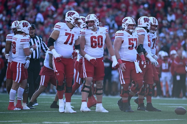 Riley Mahlman #71 of the Wisconsin Badgers and Joe Huber #60 and Jake Renfro #57 lead the offensive line against the Nebraska Cornhuskers at Memorial Stadium on November 23, 2024 in Lincoln, Nebraska.