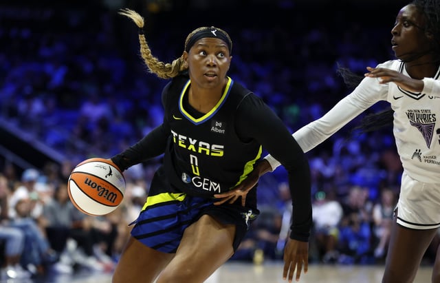 ARLINGTON, TEXAS - AUGUST 24: Amy Okonkwo #0 of the Dallas Wings handles the ball as Laeticia Amihere #3 of the Golden State Valkyries defends during the first half at College Park Center on August 24, 2025 in Arlington, Texas.