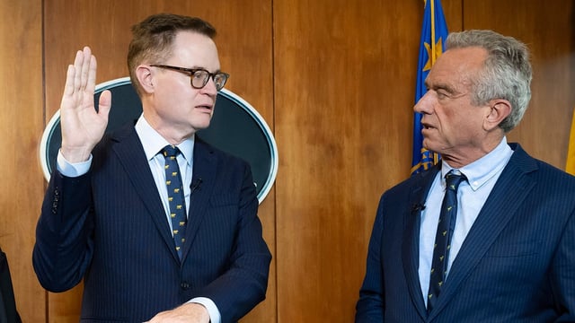 In this photo provided by the Department of Health and Human Secretary, Robert F. Kennedy, Jr., right, conducts the swearing-in ceremony of Jim O'Neill as the Department's Deputy Secretary, June 9, 2025, in Washington.