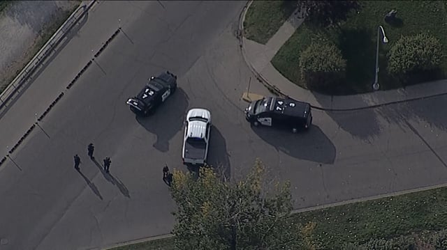 Several police officers can be seen with guns drawn along Crescent Road northwest in this shot from the Global News helicopter.