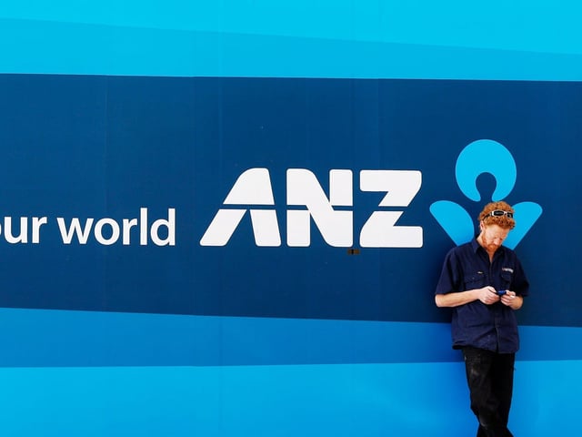 A man uses his mobile phone outside an Australia and New Zealand bank branch in central Sydney August 16, 2013.
