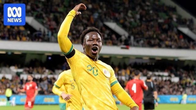 Nestory Irankunda of Australia celebrates after scoring a penalty, gesturing to fans