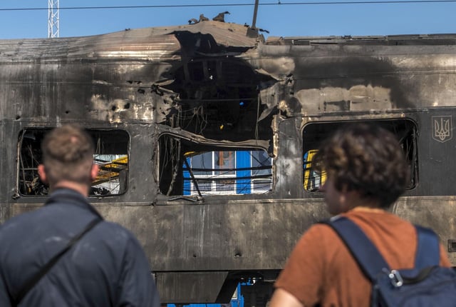 La gente observa un tren de pasajeros de alta velocidad Intercity+ dañado en un ataque ruso matutino en Kiev.