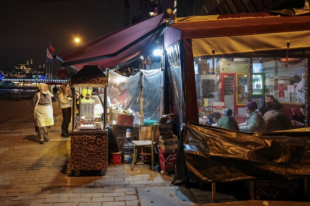Women buy food from a street vendor at a pier in Istanbul, Turkey, April 2, 2025. REUTERS/Louisa Gouliamaki/File Photo