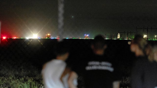 People stand near the scene where a Polish Air Force F-16 fighter jet crashed during a rehearsal for an airshow, in Radom, Poland August 28, 2025. Agencja Wyborcza.pl/Marcin Kucewicz via REUTERS   ATTENTION EDITORS - THIS IMAGE WAS PROVIDED BY A THIRD PARTY. POLAND OUT. NO COMMERCIAL OR EDITORIAL SALES IN POLAND.     TPX IMAGES OF THE DAY