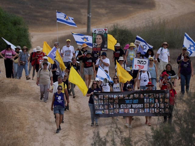 Relatives and supporters of hostages held by Hamas in the Gaza Strip take part in a protest calling for their release as they march in an area near the Israeli-Gaza border, in southern Israel, Thursday, Aug. 28, 2025. (AP Photo/Maya Levin)