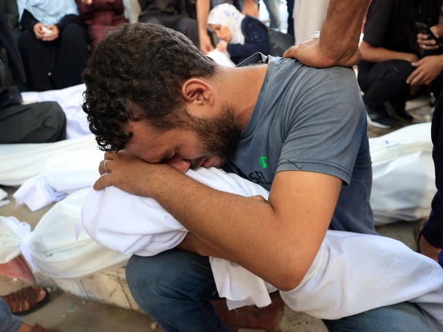 Un palestinos abraza el cuerpo de su hijo muerto en un ataque israelí en Gaza. Foto: Reuters