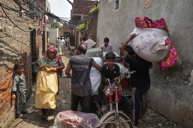 Residents retrieve belongings from their flooded home due to rising water level in Ravi River after torrential rains at a low-lying area on the outskirts of Lahore, Pakistan, Aug. 28, 2025. (AP Photo/K.M. Chaudary)