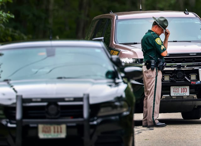 Madbury, NH – August 19: A New Hampshire State Trooper bows his head at the scene of an apparent murder suicide on Moharimet Drive on August 19, 2025. (Photo by Jonathan Wiggs/The Boston Globe via Getty Images)