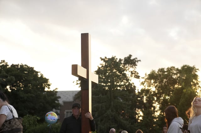 Dan beazley carries a cross at a memorial at Annunciation Catholic Church after Wednesday's school shooting, Thursday, Aug. 28, 2025, in Minneapolis. (AP Photo/Abbie Parr)