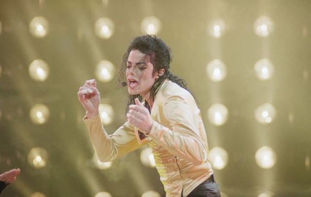 American entertainer Michael Jackson sings during his first concert in the former Soviet Union on a rainy night at Moscow’s Olympic Stadium in Moscow, Wednesday, Sept. 15, 1993. (AP Photo/Alexander Zemlianichenko)