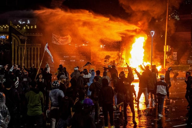 Des manifestants s’affrontent avec la police devant son quartier général de Jakarta, en Indonésie, le 29 août 2025, à la suite de la mort d’un conducteur de taxi-moto écrasé par un véhicule blindé du corps de brigade mobile la veille au soir.