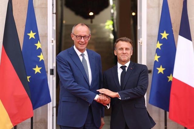 El presidente francés Emmanuel Macron estrecha la mano del canciller alemán Friedrich Merz antes de una reunión del gabinete franco-alemán