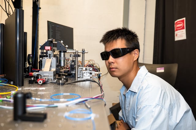 Yichi Zhang, a doctoral student in Materials Science and Engineering, inspects the source of the quantum signal. (Credit: Sylvia Zhang)