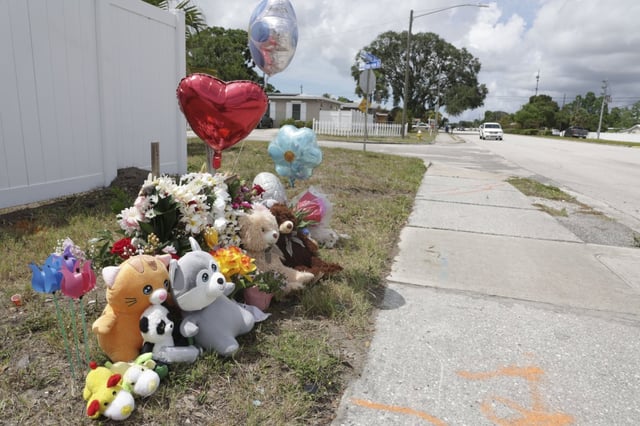 Stuffed animals, toys and balloons surround a pair of crosses on May 12 at the scene of a fatal crash two days earlier that left a woman and two children dead. Miami Hurricanes linebacker Adarius Hayes was arrested Friday on vehicular homicide and reckless driving charges in connection to the crash. (Douglas R. Clifford/Tampa Bay Times via TCA)