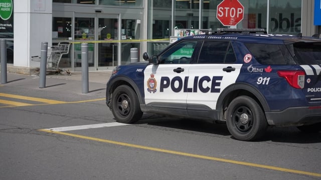 An Ottawa Police Service car sits parked outside an Ottawa grocery store after a woman was stabbed on Wednesday.
