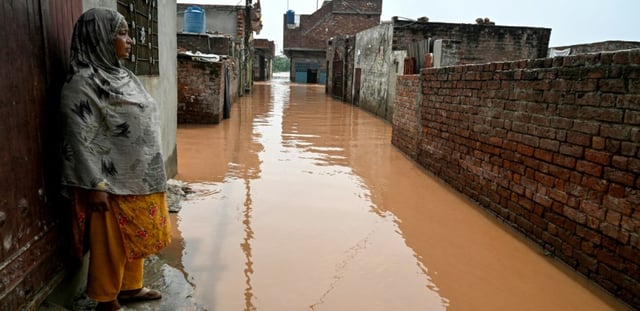 Ghulam Bano près de sa maison submergée par les eaux en crue du fleuve Ravi à Shahdara, le 29 août 2025 au Pakistan