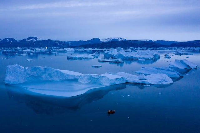Ein Boot navigiert große Eisberge in der Nähe von Kulusuk, im östlichen Grönland