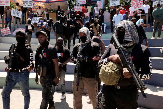 Former police officer "Commander Samuel" walks on the street surrounded by armed men from his group called Du Sang 9 during a protest against insecurity, Port-au-Prince, Haiti June 28, 2025. REUTERS/Jean Feguens Regala/File Photo