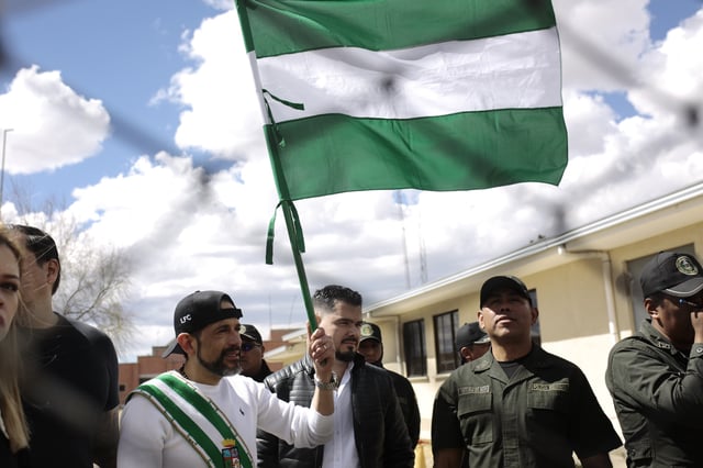 Opposition leader Luis Fernando Camacho, the suspended governor of Santa Cruz, holds up his department's flag as he is released from jail and allowed house arrest after almost three years in pretrial detention for his involvement in violent unrest that led to the 2019 ouster of then-President Evo Morales, in La Paz, Bolivia, Friday, Aug. 29, 2025. (AP Photo/Gaston Brito)