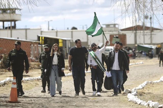 Opposition leader Luis Fernando Camacho, the suspended governor of Santa Cruz, holds up the Santa Cruz flag as he is released from jail and allowed house arrest after almost three years in pretrial detention for his involvement in violent unrest that led to the 2019 ouster of then-President Evo Morales, in La Paz, Bolivia, Friday, Aug. 29, 2025. (AP Photo/Gaston Brito)