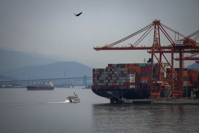 The paddle wheeler Constitution passes the container ship GSL Lydia docked at port, while sailing on the harbour as wildfire smoke hangs in the air, in Vancouver, on Thursday, Aug. 28, 2025. THE CANADIAN PRESS/Darryl Dyck