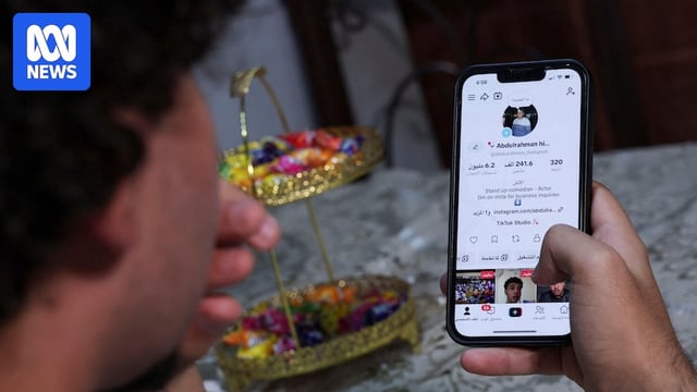 A boy looks at his phone showing a Tiktok account