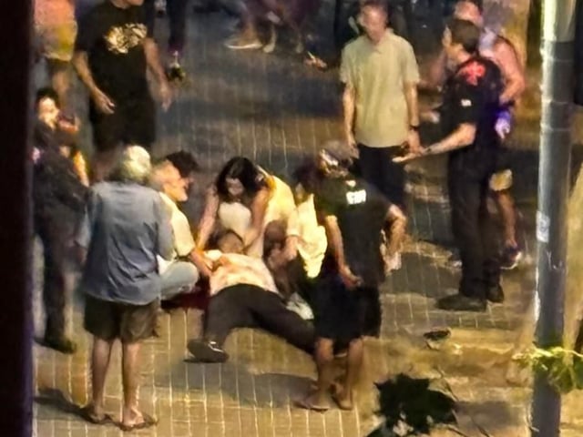 Varias personas atienden a la persona que ha recibido al menos un disparo por arma de fuego delante de un bar en la Rambla Prim, en Barcelona.