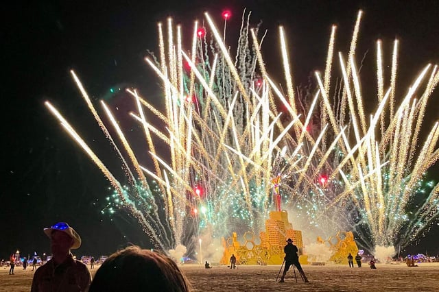 FILE: A security guard keeps people back from a fireworks display during Burning Man in 2023. A baby was born at at the festival this year.