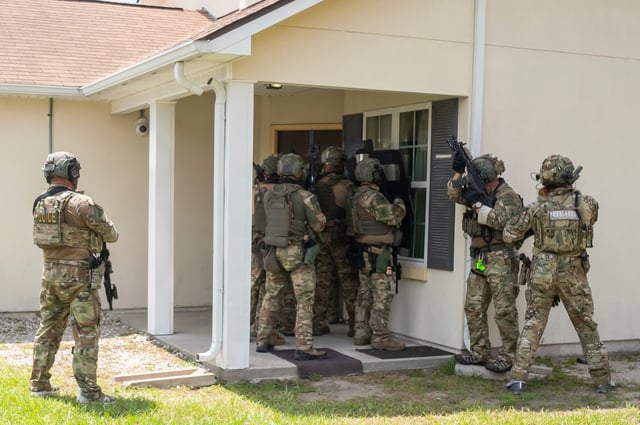 Immigration and Customs Enforcement (ICE) Special Response Team members demonstrate how the team enters a residence in the pursuit of a wanted subject at the Federal Law Enforcement Training Centers (FLETC) in Brunswick, Ga. on Thursday, Aug. 21, 2025. (AP Photo/Fran Ruchalski)