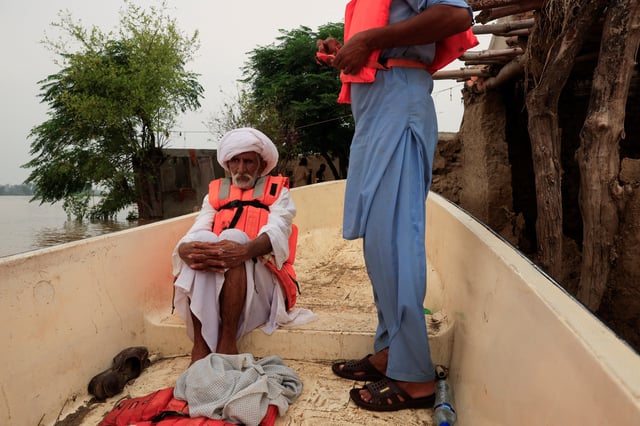 Hakim Ali Dogar, 85, a landlord wearing a lifejacket, sits in a Rescue 1122 boat evacuating people from a flooded area, following the monsoon rains and rising water level of the Sutlej River, in Chanda Singh Wala village near the Pakistan-India border in Kasur district of the Punjab province, Pakistan August 29, 2025. REUTERS/Akhtar Soomro