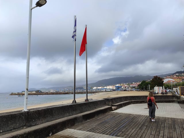 La bandera roja, ayer, en la playa de Banda do Río, prácticamente vacia por el mal tiempo.