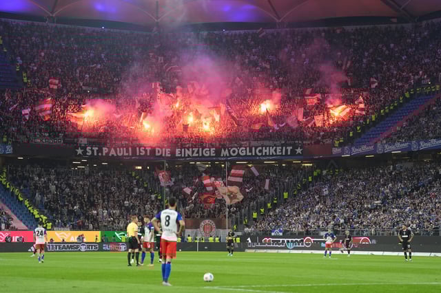 Fans des FC St. Pauli feiern im Auswärtsblock des Volksparkstadions.