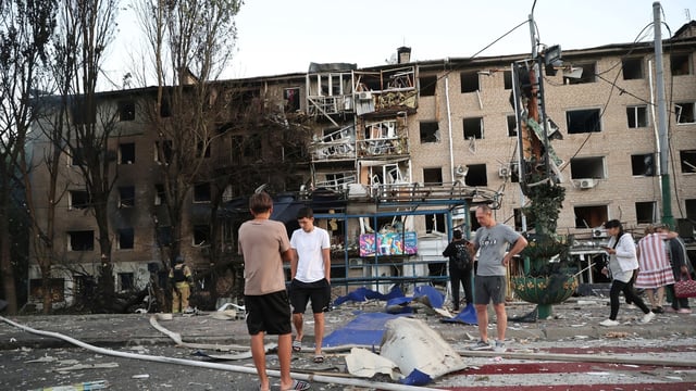 Local residents stand near their destroyed home following Russian air strike in Zaporizhzhia, Ukraine, 