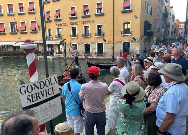 Eine Besuchergruppe wartet auf das Eintreffen von Gondeln in Venedig (Archivbild).