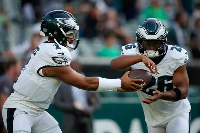 Eagles quarterback Jalen Hurts, left, hands off to running back Saquon Barkley during warmups before a preseason game against the Bengals on Aug. 7, 2025, in Philadelphia. (Matt Slocum/AP)
