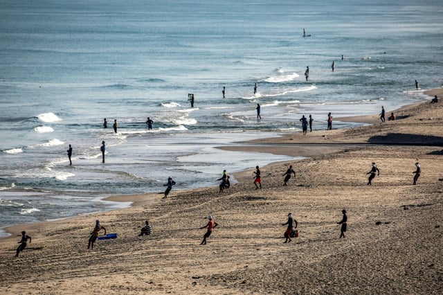 Des Palestiniens tirent leurs filets pour récupérer leurs prises sur une plage du camp de réfugiés de Nousseirat, dans le centre de la bande de Gaza, le 30 août 2025