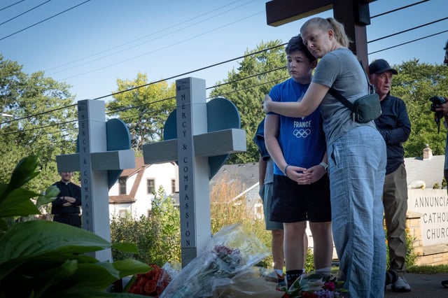 People visit a memorial of shooting victims in front of Annunciation Catholic Church on August 28, 2025 in Minneapolis, Minnesota.