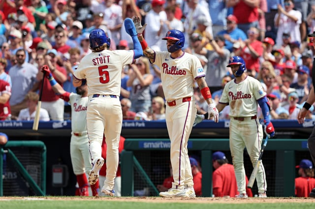 PHILADELPHIA, PENNSYLVANIA - AUGUST 24: Bryson Stott #5 of the Philadelphia Phillies high-fives Nick Castellanos #8 after they both scored in the second inning during a game against the Washington Nationals at Citizens Bank Park on August 24, 2025 in Philadelphia, Pennsylvania.