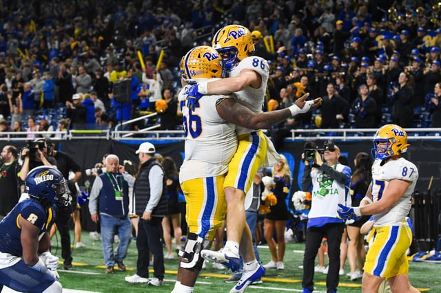 Lyndon Cooper #56 (L) and Gavin Bartholomew #86 of the Pittsburgh Panthers celebrate after a play during overtime of the GameAbove Sports Bowl against the Toledo Rockets at Ford Field on December 26, 2024 in Detroit, Michigan. The Toledo Rockets won the game 48-46.