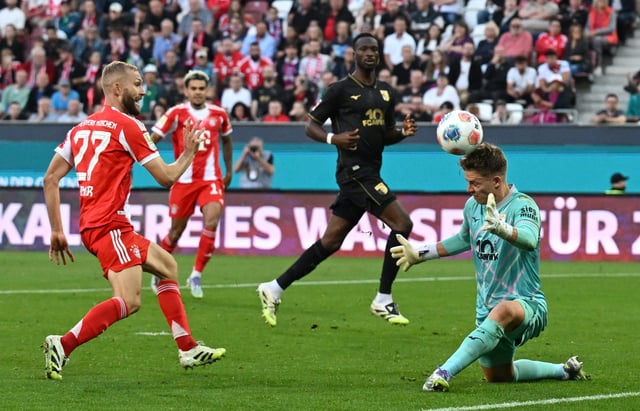 Soccer Football - Bundesliga - FC Augsburg v Bayern Munich - WWK Arena, Augsburg, Germany - August 30, 2025 Bayern Munich's Konrad Laimer in action with FC Augsburg's Finn Dahmen REUTERS/Angelika Warmuth