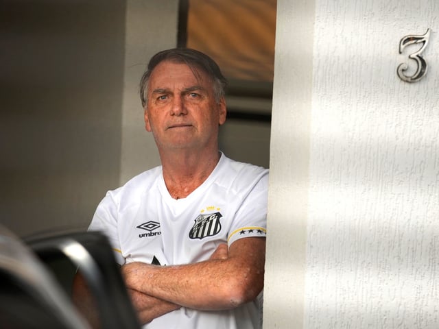 Brazil's former President Jair Bolsonaro stands at the entrance to his home where he is under house arrest in Brasilia, Brazil, Friday, Aug. 29, 2025. (AP Photo/Eraldo Peres)